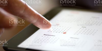 Finger of an elderly woman pointing at the surface of a tablet computer
